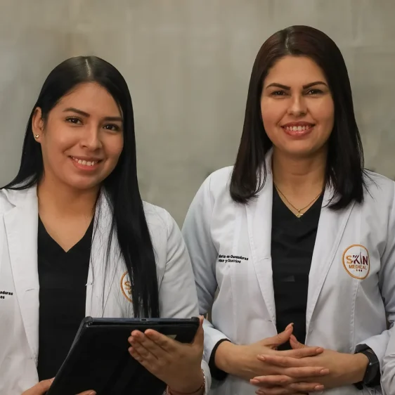 Dos especialistas de Skin Medical, expertas en quemaduras y cicatrices, sonrĂen con batas mĂ©dicas.